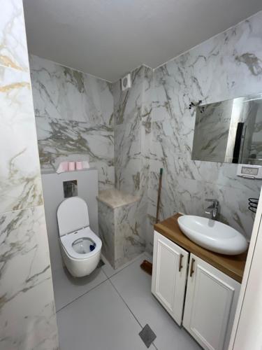 biała łazienka z toaletą i umywalką w obiekcie סוויטת קריית צאנז w mieście Netanja
