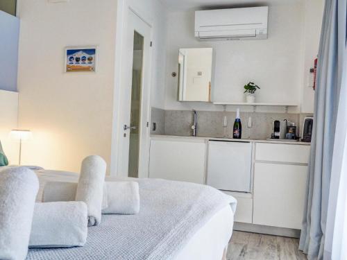 a white room with a bed and a kitchen at Blue Serenity by Hello Homes Sitges in Sitges