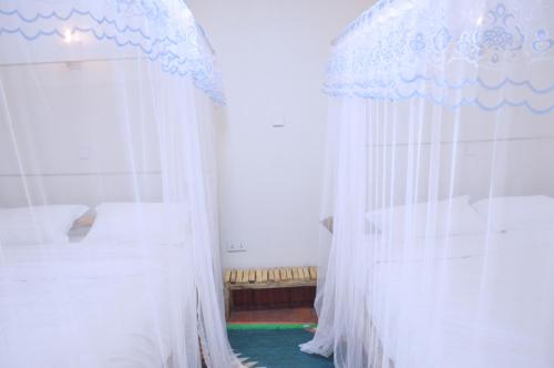 a bedroom with two beds and a canopy at Kabalega Diner Limited in Nakitoma