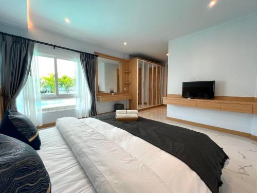 a large bedroom with a large bed and a television at City house- 171, Private pool villa 4 bed5bath near walking St, BBQ in Pattaya South