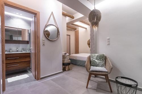 ein Badezimmer mit einem Waschbecken, einem Spiegel und einem Stuhl in der Unterkunft The Cactus Project in Loutraki