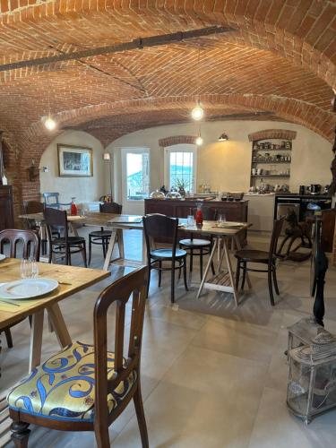 une salle à manger avec des tables et des chaises en bois dans l'établissement Antica Cascina Pilo, à Monchiero