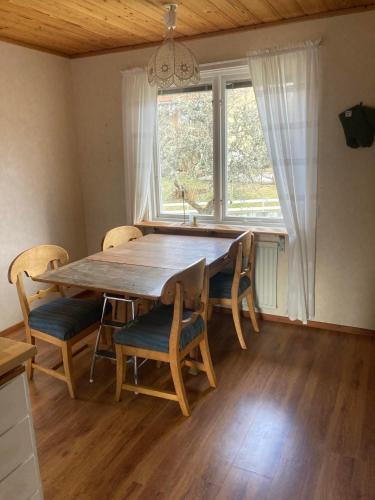 BlankaholmにあるSolvillanのダイニングテーブルと椅子、そして大きな窓