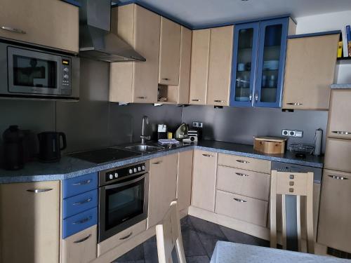 a kitchen with white cabinets and blue appliances at Ferienhaus mit Terrasse und viel Ruhe in Wieting