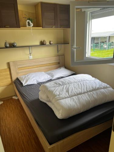 łóżko w pokoju z oknem w obiekcie Luxe Stacaravan Albatros - 51 w mieście Bredene