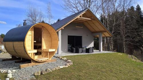 una pequeña casa con una gran estructura de madera en Dom nad Stryszawką z SAUNĄ - domek wypoczynkowy, en Stryszawa