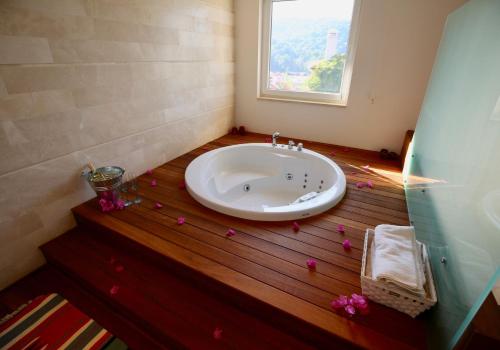 een badkamer met een wastafel met bloemblaadjes op de vloer bij 7 Gocek Royal in Belenpınar
