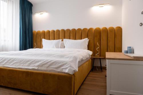 a bedroom with a large bed with a wooden headboard at Scandinavia Apartment 2 in Piatra Neamţ