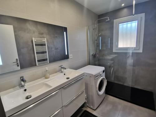 une salle de bain avec un lavabo et une machine à laver dans l'établissement Haut de villa VERMEER, à Six-Fours-les-Plages