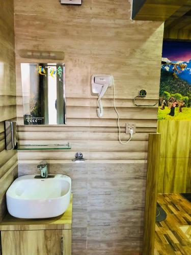 a bathroom with a sink and a mirror at Sara's Backpackers Hotel in Kathmandu
