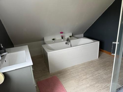 une salle de bain avec une baignoire blanche dans une chambre dans l'établissement la louisiane, à Ambleteuse