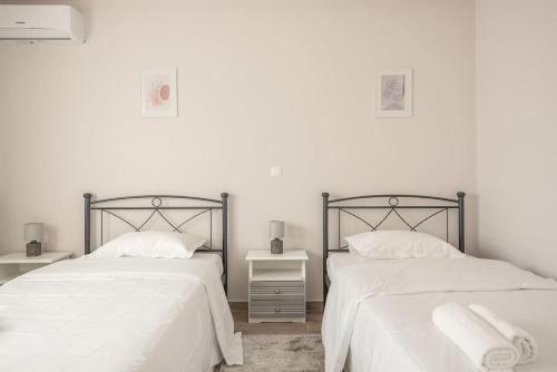 duas camas uma ao lado da outra em um quarto em City Nexus Family 2BD residence Kolonos, Athens em Atenas