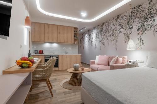 eine Küche und ein Wohnzimmer mit einem Bett und einem Tisch in der Unterkunft Loutraki Flamingo Feather in Loutraki