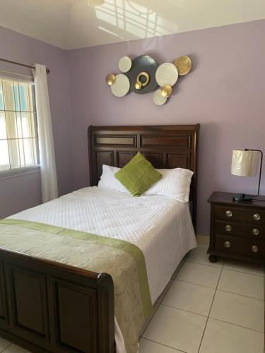 Schlafzimmer mit einem Bett mit einem Kopfteil aus Holz in der Unterkunft Vacation Getaway in Mango Walk Country Club in Montego Bay