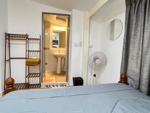1 dormitorio con cama y baño con espejo. en เพชรบูรณ์ แอทโฮม, en Phetchabun