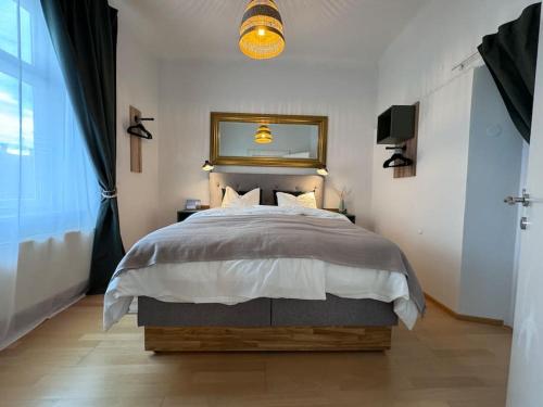 ein Schlafzimmer mit einem Bett und einem Spiegel darüber in der Unterkunft LendLoft: Altbaumodern & Lendviertel Chic in Klagenfurt am Wörthersee