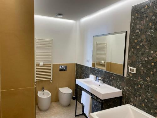 a bathroom with a sink and a toilet and a mirror at Oasi Village Hotel in Milan