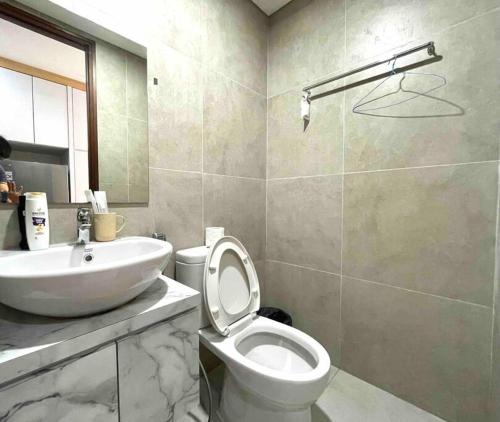 een badkamer met een wit toilet en een wastafel bij Aesthetic Studio Unit in Bluhen Tower in Batam Center