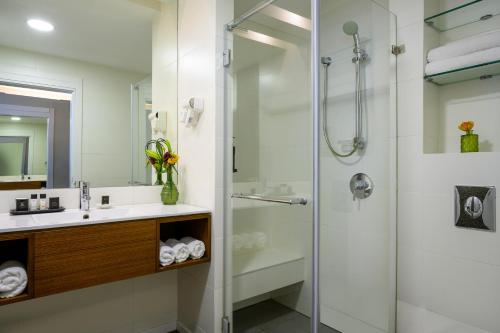 y baño con ducha y lavamanos. en Sadot Hotel Ben Gurion Airport - an Atlas Boutique Hotel, en Assaf Harofeh