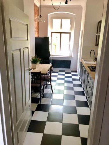 a kitchen with a black and white checkered floor at Apartament na piasku in Gliwice