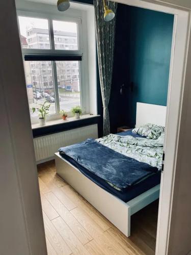 a small bedroom with a bed in a room with a window at Apartament na piasku in Gliwice