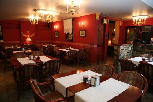 a restaurant with tables and chairs and red walls at Hotel Villa Viktorija in Banja Luka