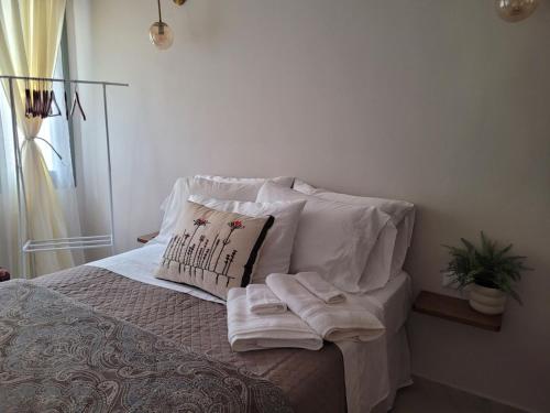 a bed with white pillows and towels on it at City Center Suites in Karpathos Town