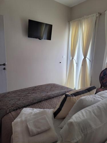 a bedroom with two beds and a television on the wall at City Center Suites in Karpathos Town