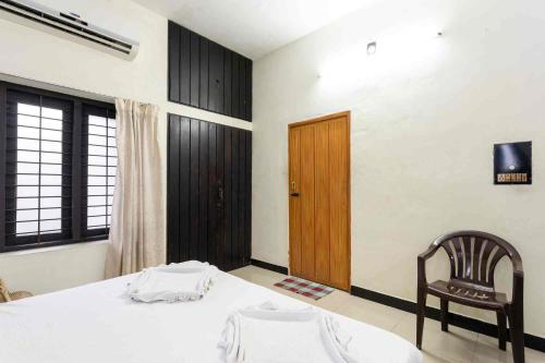 una camera con un letto, una sedia e una porta di Shez Holiday Villa Vacation House in Trincomalee a Trincomalee