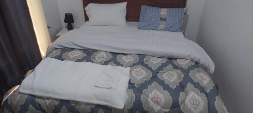 a bed with a blue and white bedspread and pillows at RUbuto ABNB in Kigali