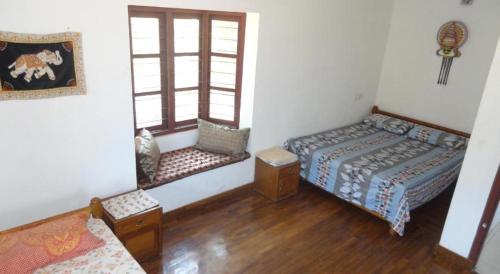 un soggiorno con 2 letti e una finestra di Shez Holiday Villa Vacation House in Trincomalee a Trincomalee