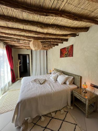 a bedroom with a large bed and a wooden ceiling at Kasbah La Cigogne in Aït Ben Haddou