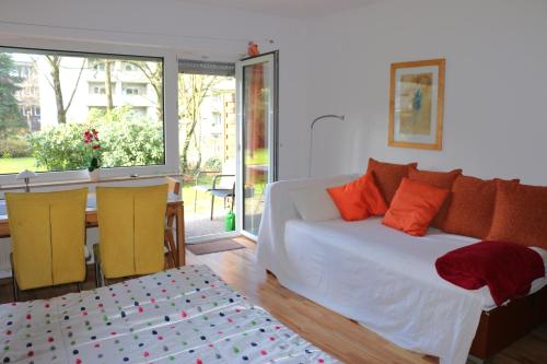 埃森的住宿－Essen City quiet flat with terrace and garden，卧室配有带橙色枕头的白色床