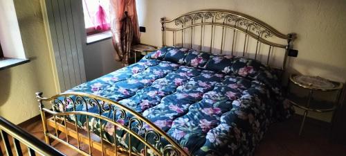 Una cama con un edredón azul con flores. en Maison du Soleil- CIR VDA Valtournenche n 0204, en Valtournenche