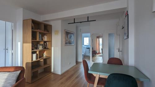 ein Wohnzimmer mit einem grünen Tisch und Stühlen in der Unterkunft Appartement lumineux et cosy avec balcon - 3P in Les Lilas