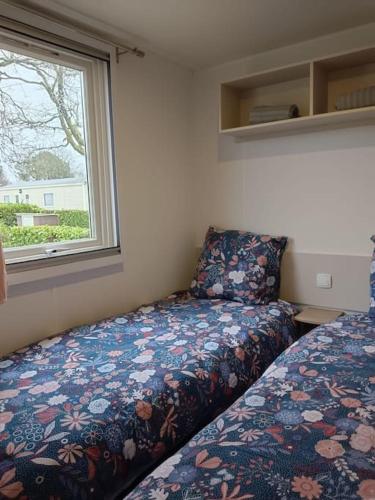 une petite chambre avec un lit et une fenêtre dans l'établissement Bungalow Pont- aven, à Pont-Aven