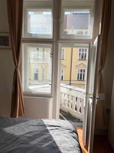 a bedroom with a window with a view of a building at Muchovka Apartment in Prague