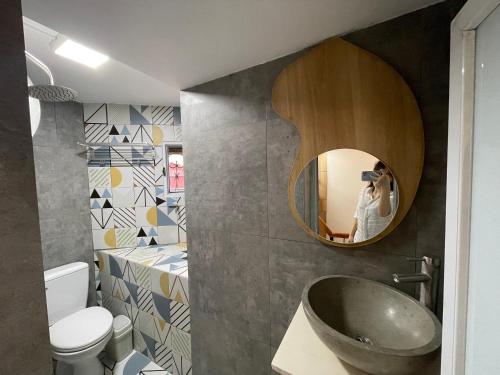 uma pessoa a tirar uma foto de uma casa de banho com um lavatório em Mimi Housing em Hanói