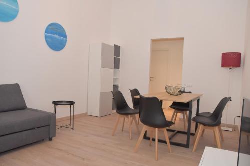 Una sala de estar con un sofá, una mesa y sillas. en Casa Emma, en Ancona