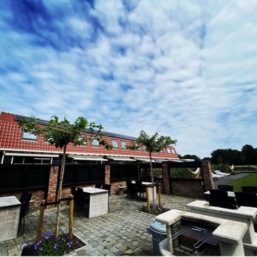 a patio with tables and chairs and a building at Vakantiewoningen de Schelp in Renesse