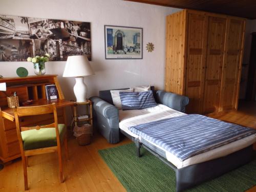 ein Schlafzimmer mit einem Sofa, einem Stuhl und einem Schreibtisch in der Unterkunft Gästezimmer im Freudenthal in Extertal