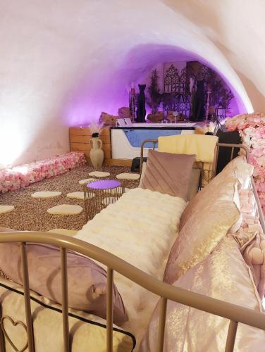 ein Schlafzimmer mit einem Bett in einem Zimmer mit lila Beleuchtung in der Unterkunft L'Atelier Des Roses in Lunéville