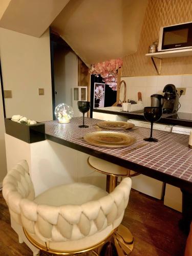eine Küche mit einer Theke und eine Bar mit einem Stuhl in der Unterkunft L'Atelier Des Roses in Lunéville
