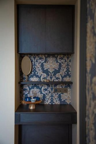 une salle de bain avec un lavabo et un miroir sur un mur dans l'établissement Les Palissières - Chambres d'Hôtes, à Mortagne-sur-Gironde