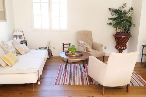 ein Wohnzimmer mit 2 weißen Sofas und einem Tisch in der Unterkunft Villa Libellules lac et mer in Soorts-Hossegor