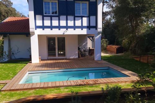 une maison avec une piscine dans la cour dans l'établissement Villa Libellules lac et mer, à Soorts-Hossegor