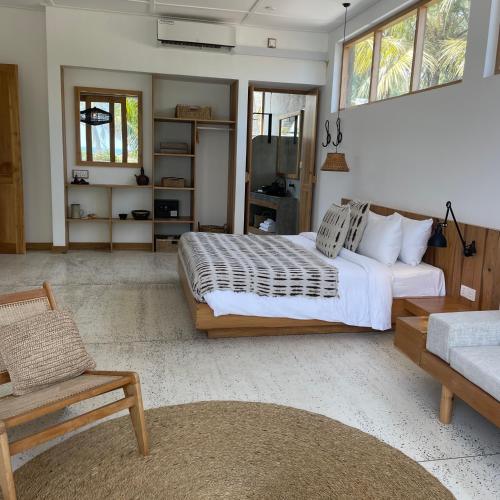 a bedroom with a large bed and a couch at La Playa Beach Club in Hiriketiya