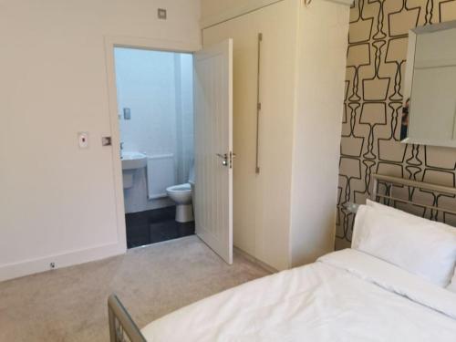 a bedroom with a bed and a bathroom with a toilet at Riverside Cockatoo's Cottage Charming 3 Bed Retreat for up to 10 Guests in Stockton-on-Tees