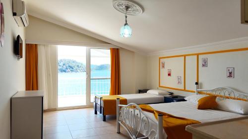 a hotel room with two beds and a large window at Yazıcı Otel Bozburun in Marmaris