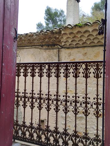 an iron fence in front of a stone wall at Les Studios de St Guilhem in Saint-Guilhem-le-Désert